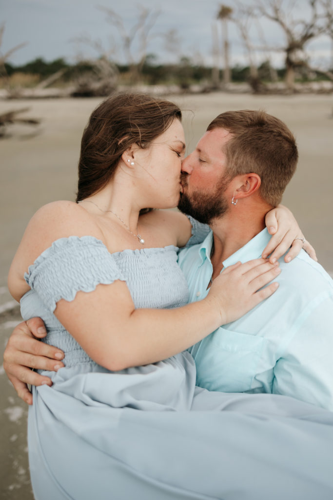 Couple kissing at Driftwood Beach engagement session 