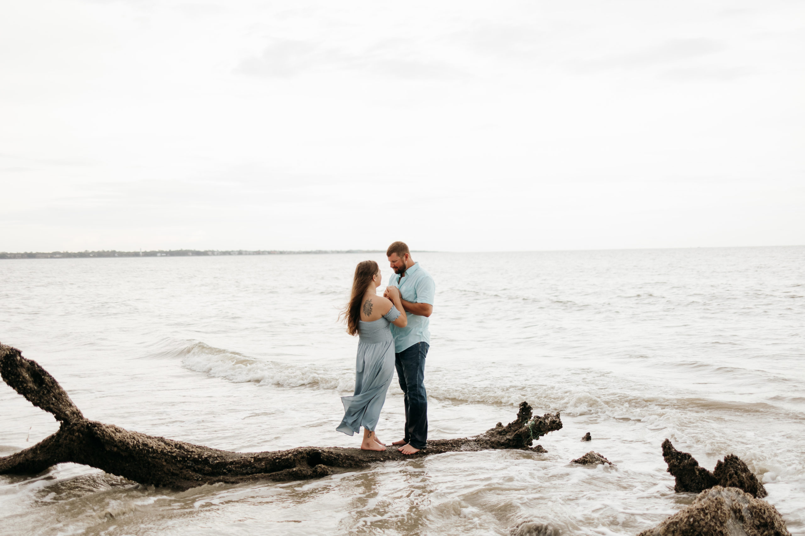 Couple standing on the beach during Jekyll Island Driftwood Beach Engagement session