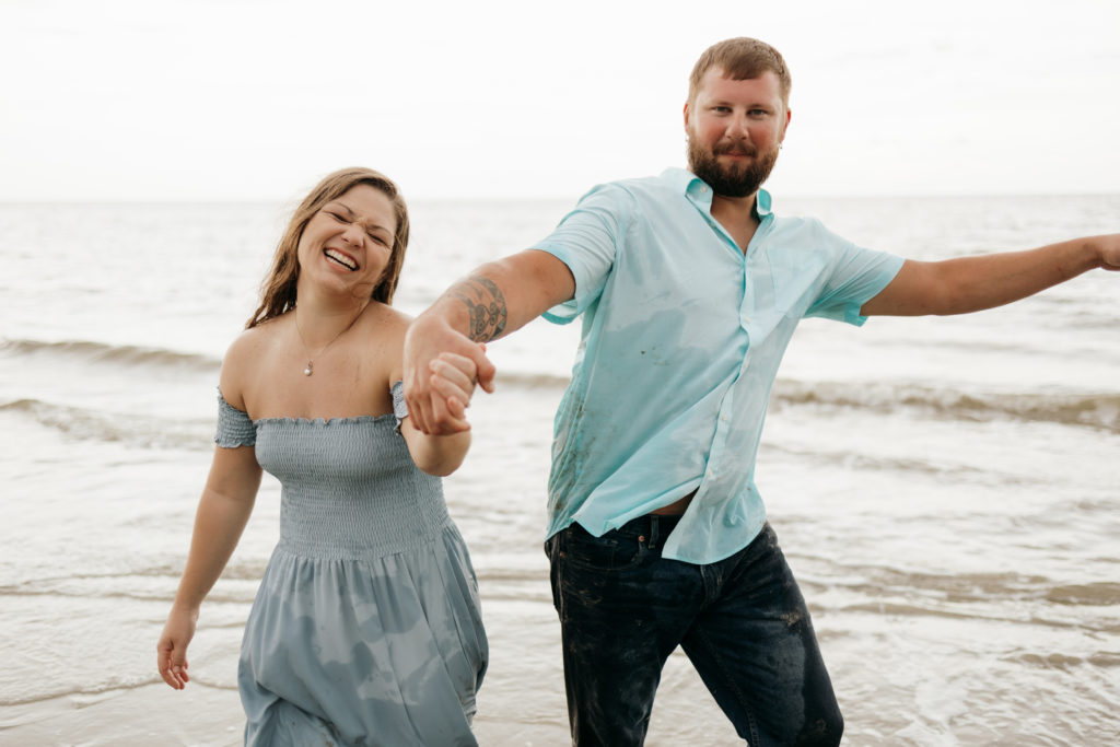 Couple posing on Driftwood Beach for engagement session 