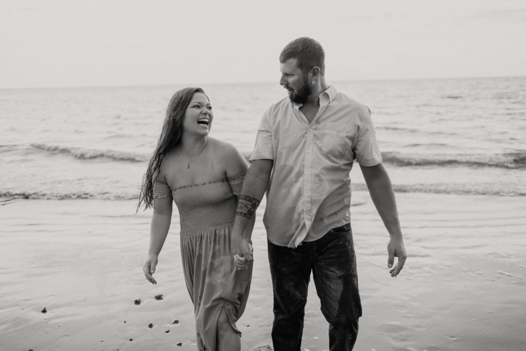 Couple laughing during Georgia engagement beach session 